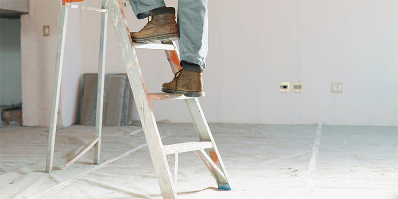 Construction Worker Stepping on LAdder