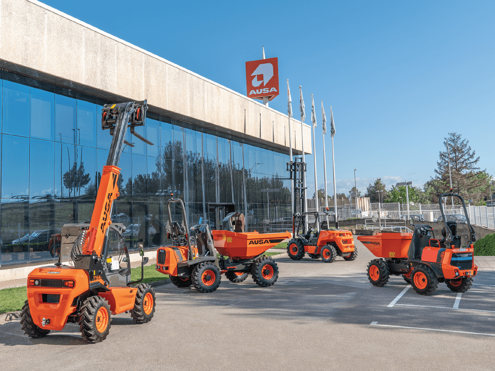 Orange AUSA construction equipment outside a building