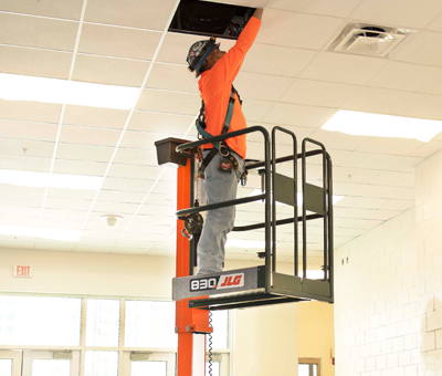 Operator completing facility maintenance with JLG® 830P push around lift