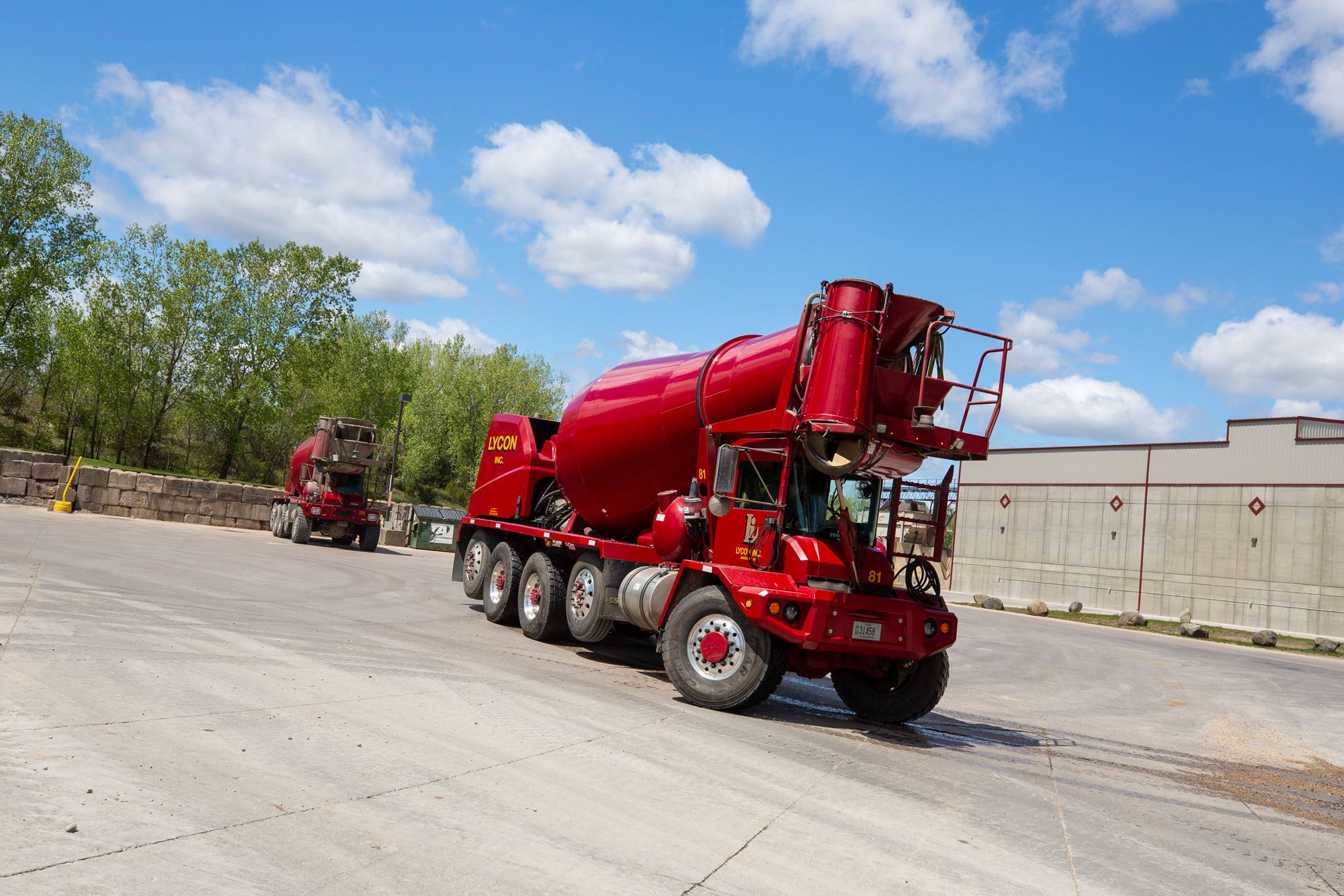 Red Oshkosh S-Series front discharge mixer showing off its turning radius outdoors on a sunny day