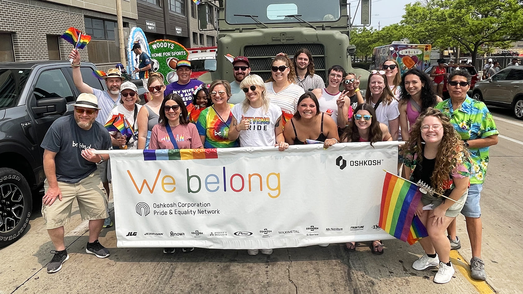 Group of Oshkosh team members smiling for a group photo as they support the Milwaukee Pride Parade 